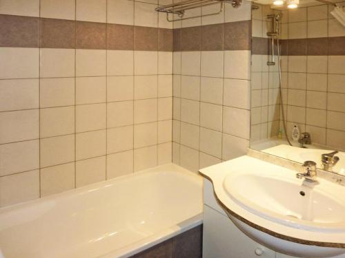 une salle de bain avec une baignoire blanche et un lavabo dans l'établissement Les Chalets De Bois Mean - Résidence le Bois Méan 2 pièces pour 6 personnes MAE-0704, aux Orres
