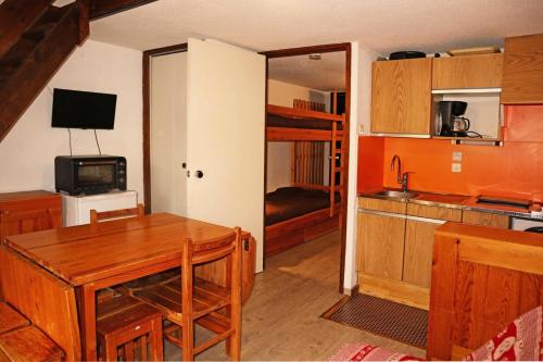 Il comprend une cuisine avec une table et des lits superposés. dans l'établissement Résidence Le Pouzenc - Studio 6 personnes accès direct aux pistes MAE-0674, aux Orres