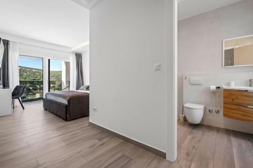 ein Schlafzimmer mit einem Bett und ein Badezimmer mit einem Waschbecken in der Unterkunft Villa Summer side by Istrialux in Marina