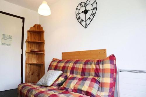 un salon avec un canapé et une horloge au mur dans l'établissement Résidence Les Gradins - 32 LES GRADINS lES ORRES 1650 MAE-0744, aux Orres