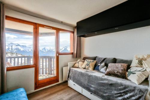 un salon avec un canapé et une grande fenêtre dans l'établissement Résidence L'Ours Blanc - maeva Home - Studio 5 Personnes - Sélection MAE-4232, à Huez