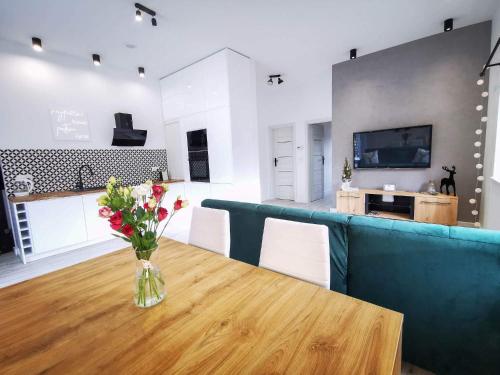 uma sala de estar com uma mesa e um sofá azul em Apartament Roku 2024' - JELEŃ & NATURA em Kudowa-Zdrój