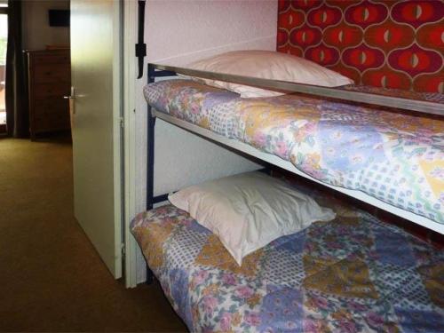 sypialnia z 2 łóżkami piętrowymi i poduszką w obiekcie Résidence L'EPERVIERE - Studio pour 4 Personnes 754 w mieście Les Orres