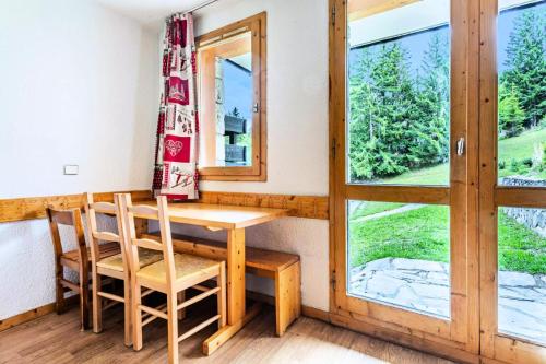 une table et des chaises dans une pièce avec une fenêtre dans l'établissement Résidence Les Brigues - maeva Home - Appartement 2 Pièces 6 Personnes - Confort MAE-4698, à Courchevel