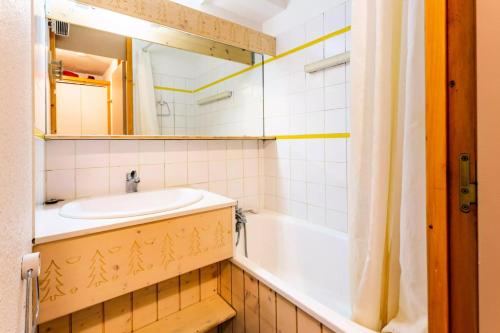 une salle de bain avec un lavabo, une baignoire et un miroir dans l'établissement Résidence Les Brigues - maeva Home - Appartement 2 Pièces 6 Personnes - Confort MAE-4698, à Courchevel