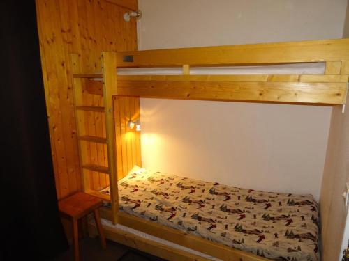 a bedroom with a bunk bed with a ladder at Résidence Grand Arbois - Studio pour 4 Personnes 57 in Arc 1800