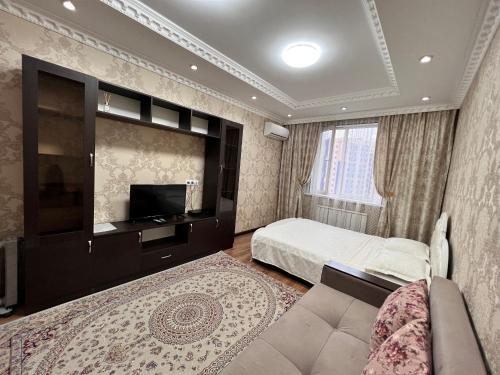 een slaapkamer met een bed en een flatscreen-tv bij Apartmens in Complex Almaly 83-51 in Alma-Ata