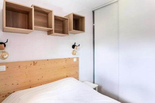 - une petite chambre avec un lit et des placards en bois dans l'établissement Résidence Le Thabor - maeva Home - Appartement 2 Pièces 5 Personnes - Sélection MAE-4741, à Le Désert