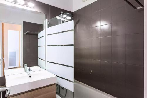 une salle de bain avec un lavabo et un miroir dans l'établissement Résidence Le Thabor - maeva Home - Appartement 2 Pièces 5 Personnes - Sélection MAE-4741, à Le Désert
