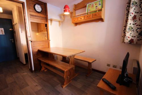 une chambre avec une table, un banc et une horloge dans l'établissement Résidence Praz De L'ours 1 - Studio 4 personnes à Vallandry en centre station et proche des pistes MAE-1960, à Peisey-Nancroix