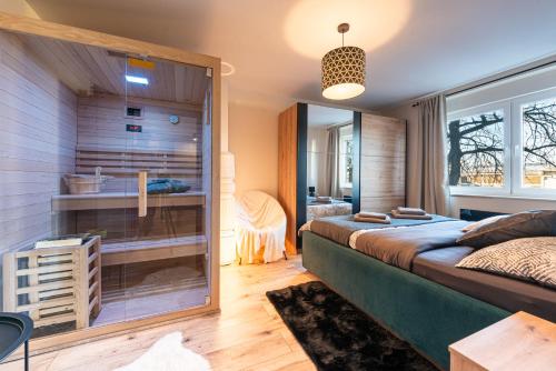 a bedroom with a large bed and a glass wall at Apartman Dior - sauna, self check in in Belišće