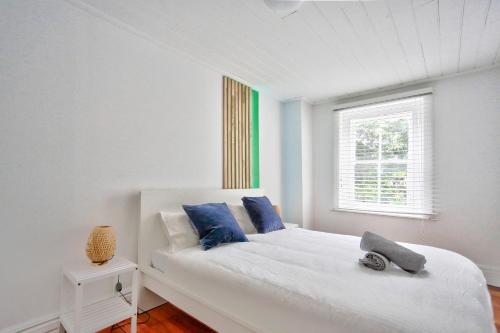 a white bedroom with a white bed with blue pillows at Family Friendly 3 Bedroom House Glebe 2 E-Bikes Included in Sydney