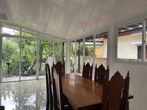 uma sala de jantar com uma mesa de madeira e cadeiras em Fully furnished spacious house in Nuvali em Calamba