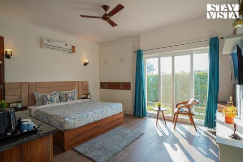 a bedroom with a bed and a large window at Hriday Bhoomi with Pool at Jim Corbett by StayVista in Jhirna
