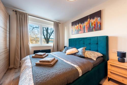 a bedroom with a blue bed with a blue headboard at Apartman Dior - sauna, self check in in Belišće