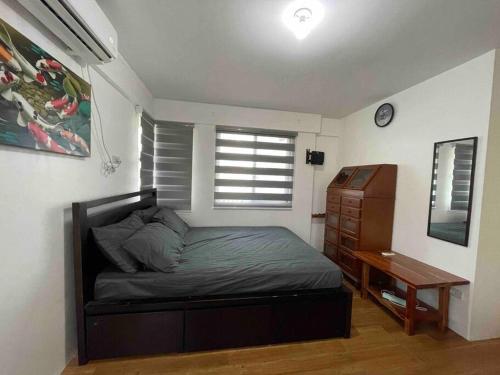 um quarto com uma cama, uma secretária e uma janela em Fully furnished spacious house in Nuvali em Calamba