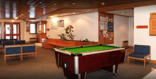 Cette chambre comprend une table de billard et des chaises. dans l'établissement Résidence Les Brigues - maeva Home - Appartement 2 Pièces 6 Personnes – Confort MAE-4702, à Courchevel