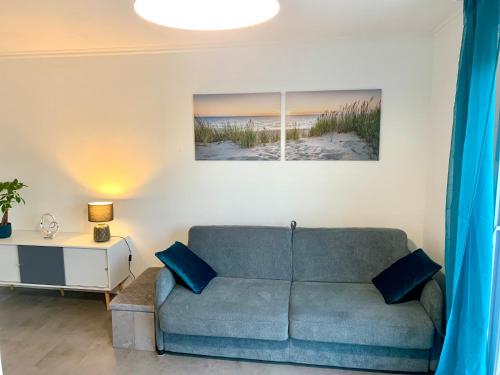 a living room with a couch and a table at Le courant d’air in Fort-Mahon-Plage