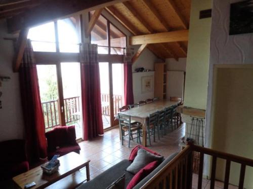 un salon avec une table et une grande fenêtre dans l'établissement Beau chalet au départ des pistes - Chalet 6 pièces 12 personnes MAE-4869, à Aime La Plagne