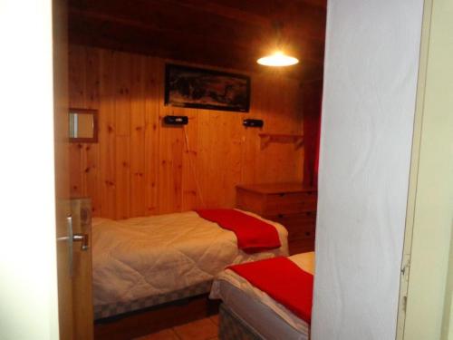 - une chambre avec 2 lits dans une pièce dotée de murs en bois dans l'établissement Beau chalet au départ des pistes - Chalet 6 pièces 12 personnes MAE-4869, à Aime La Plagne