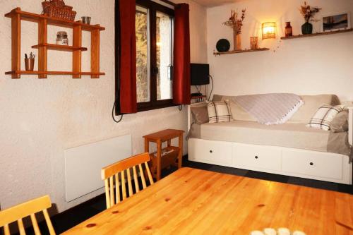萊索爾的住宿－Résidence LA SEILLE - Studio pour 4 Personnes 974，一间卧室配有一张床和一张木桌