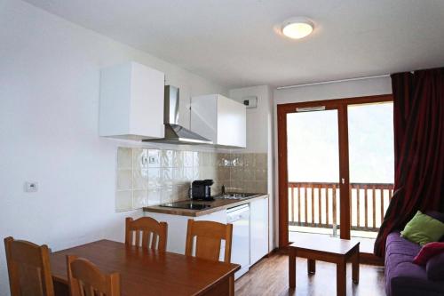 une cuisine et une salle à manger avec une table et une cuisine et une salle à manger dans l'établissement Résidence Les Chaltes Bois Mean - Résidence le Bois Méan 2 pièces 4 personnes MAE-1074, aux Orres