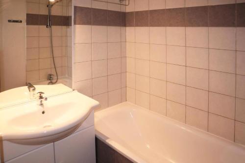 uma casa de banho com um lavatório e uma banheira em Résidence LES CHALTES BOIS MEAN - 2 Pièces pour 4 Personnes 074 em Les Orres
