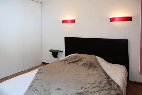 - une chambre avec un lit et deux lumières rouges sur le mur dans l'établissement Residence La Combe D Or - Appartement en résidence de standing MAE-6314, aux Orres