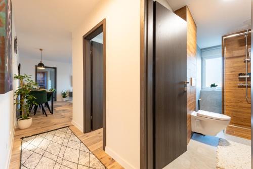 baño con aseo y puerta de madera en Apartman Dior - sauna, self check in, en Belišće