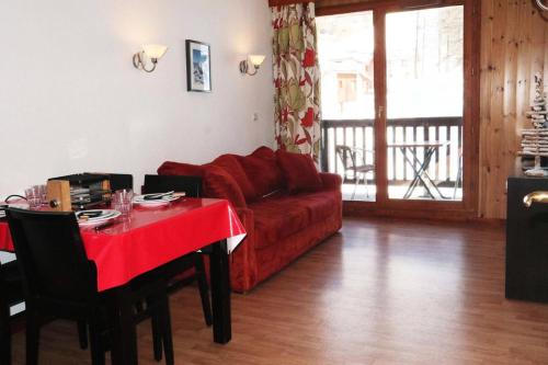un salon avec un canapé rouge et une table dans l'établissement Residence La Combe D Or - Appartement en résidence de standing MAE-6324, aux Orres