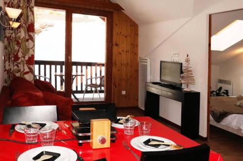 a living room with a table with a red table cloth at RESIDENCE LA COMBE D OR - 2 Pièces pour 4 Personnes 324 in Les Orres