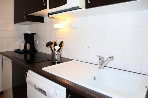 a kitchen with a sink and a counter top at RESIDENCE LA COMBE D OR - 2 Pièces pour 4 Personnes 324 in Les Orres