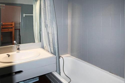 W łazience znajduje się umywalka i wanna. w obiekcie Résidence Le Cairn - Studio pour 4 Personnes 054 w mieście Les Orres