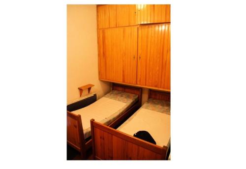 two beds in a room with wooden cabinets at Résidence Bellevue A - maeva Home - Studio 4 Personnes - Budget 36 in Orcières