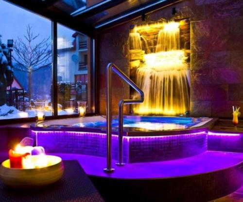 eine Whirlpool-Badewanne in einem Zimmer mit Wasserfall in der Unterkunft Apartament Roku 2024' - JELEŃ & NATURA in Kudowa-Zdrój