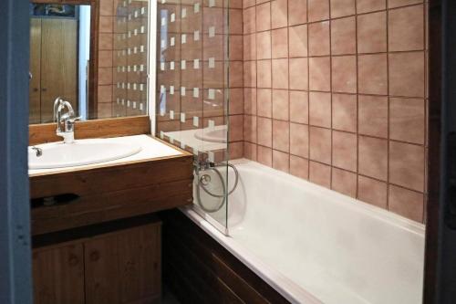 une salle de bain avec un lavabo, une baignoire et un miroir dans l'établissement Résidence Le Cairn - Studio 6 personnes 1650 MAE-1914, aux Orres