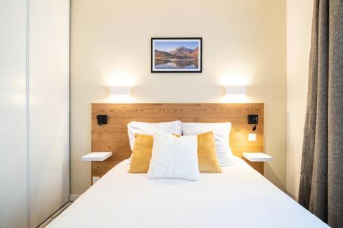 sypialnia z białym łóżkiem z 2 lampami w obiekcie Résidence Les Rives de L'Aure - maeva Home - Appartement 2 pièces 5 personnes - Sélection MAE-6737 w mieście Saint-Lary-Soulan