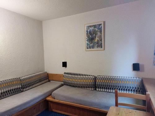 une salle d'attente avec deux bancs et une photo sur le mur dans l'établissement Résidence Nova - Studio 2 personnes, proche des pistes et des commerces, au cœur de la station d’Arc 1800 dans le village des Villards MAE-1988, à Arc 1800