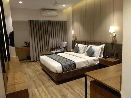 a hotel room with a bed and a desk at Pinnacle Grand Hotel in Ahmedabad