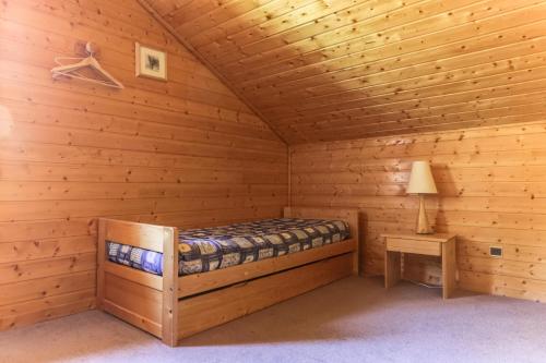 a log cabin with a bed and a table at Chalet Forsythia - Chalets pour 10 Personnes 91 in Peisey-Nancroix