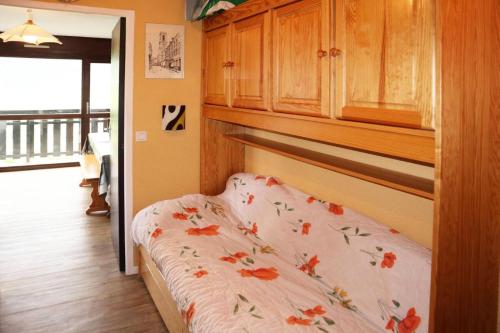 a bedroom with a bed with flowers on it at Résidence Les 7 Berge - Studio pour 5 Personnes 614 in Les Orres