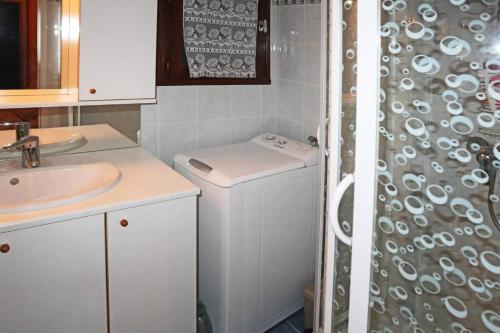 a bathroom with a sink and a washing machine at Résidence Les 7 Berge - Studio pour 5 Personnes 614 in Les Orres