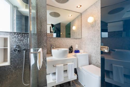 ein Bad mit einem Waschbecken, einem WC und einer Dusche in der Unterkunft The Aberdeen Harbour by Ovolo in Hongkong