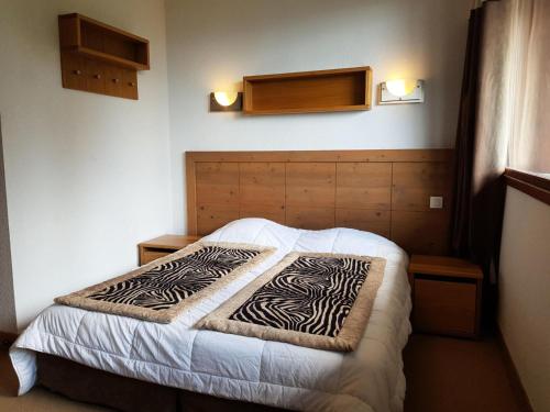 een slaapkamer met een bed met een zebradeken erop bij Résidence Roc Belleface C - 3 Pièces pour 8 Personnes 98 in Arc 1600