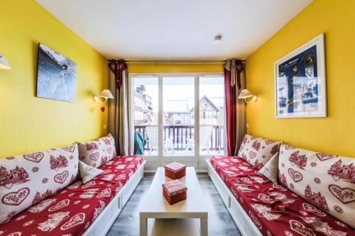 uma sala de estar com um sofá vermelho e uma janela em Résidence Le Thabor - maeva Home - Appartement 2 Pièces 5 Personnes - Confo 73 em Le Désert