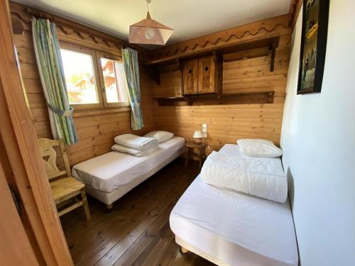 une chambre avec deux lits dans une cabane en rondins dans l'établissement Résidence Les Fermes de Méribel - maeva Home - Appartement 3 pièces 6 personnes Sélection MAE-7183, à Les Allues