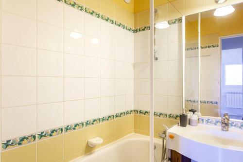 uma casa de banho com uma banheira e um lavatório em Résidence Le Thabor - maeva Home - Appartement 2 Pièces 5 Personnes - Confo 73 em Le Désert