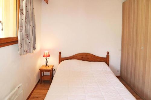 - une chambre avec un lit blanc et une lampe sur une table dans l'établissement Résidence Les Colchiques - 2 Pièces pour 6 Personnes 604, aux Orres