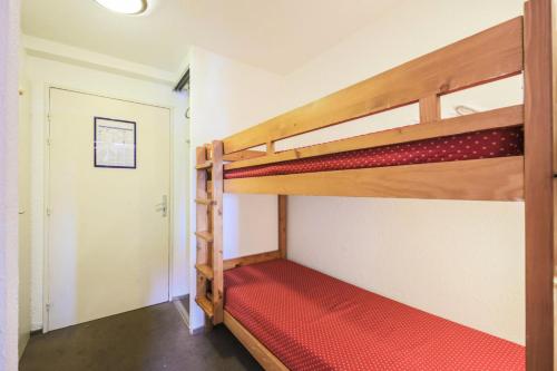 Cette chambre comprend 2 lits superposés et un matelas rouge. dans l'établissement Résidence Les Horizons d'Huez - maeva Home - Studio 4 personnes Confort MAE-7170, à Huez