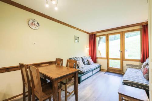 un salon avec une table et un canapé dans l'établissement Résidence La Marelle et Le Rami - maeva Home - Appartement 2 Pièces 5 Personnes - Sélection MAE-7484, à La Plagne Tarentaise